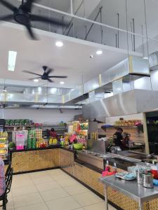 a large kitchen with people preparing food in a store at Ampang Neu Suites by DreamOak in Kuala Lumpur
