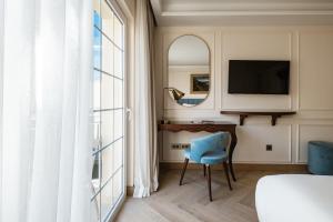 a bedroom with a desk and a blue chair next to a window at Palazzo Castagna Boutique Hotel in Hal Ghaxiak