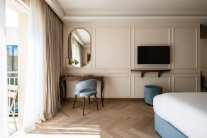 una camera da letto con un letto, una scrivania e una TV di Palazzo Castagna Boutique Hotel a Hal Ghaxiak