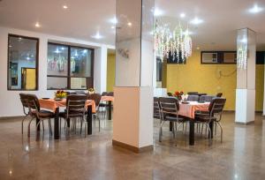 a dining room with tables and chairs and a chandelier at Nikko Blue - Boutique Hotel in Gurgaon