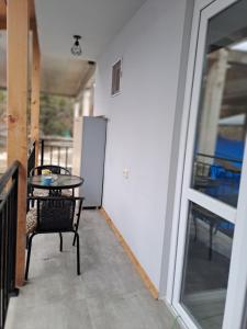 un patio con tavolo e sedie sul balcone. di Ira & Vaso's guest house Borjomipark a Borjomi