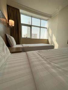 a hotel room with two beds and a window at فندق أبراج نوازي Nawazi Towers Hotel in Makkah