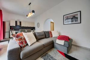 un soggiorno con divano e una cucina di St Julians apartment 1 a San Giuliano
