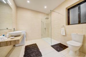 a bathroom with a toilet and a sink and a shower at St Julians apartment 1 in St Julian's +23 photos