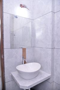 ein weißes Badezimmer mit einem Waschbecken und einem Spiegel in der Unterkunft HOTEL D SQUARE . in Shirdi