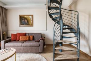 a spiral staircase in a living room with a couch at Palazzo Castagna Boutique Hotel in Hal Ghaxiak