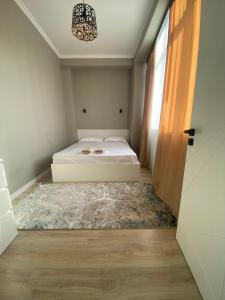 1 dormitorio con cama blanca y ventana en ЖК Ламия en Almaty
