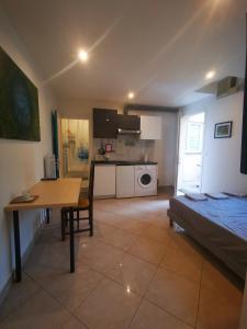 a living room with a bed and a table and a kitchen at Cosy studio pour deux personnes in Vitry-sur-Seine +12 photos
