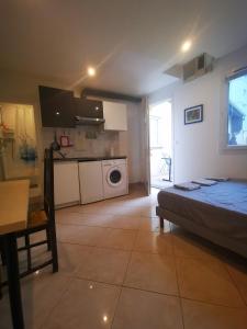 sala de estar con cama y cocina en Cosy studio pour deux personnes en Vitry-sur-Seine
