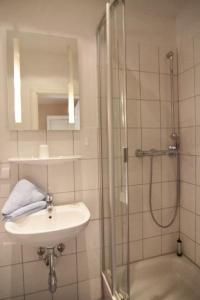 a bathroom with a sink and a shower at Kapitaenshaus-Lassen-Zimmer-Sindbad in Westerland (Sylt)