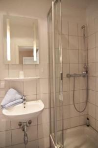 a bathroom with a sink and a shower at Kapitaenshaus-Lassen-Zimmer-Sindbad in Westerland