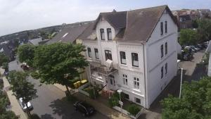 uma vista superior de uma grande casa branca em Kapitaenshaus-Lassen-Zimmer-Sindbad em Westerland