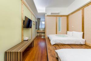 a hotel room with a bed and a tv at 綠之丘 l 寵物友善 in Taitung City