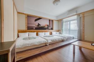 a bedroom with two beds and a large window at 綠之丘 l 寵物友善 in Taitung City