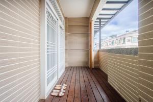 a balcony with wooden flooring and a large window at 綠之丘 l 寵物友善 in Taitung City