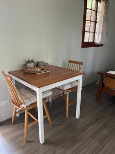 a dining room table with two chairs and a table at Three Rivers Cabin in Yandina
