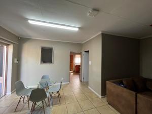 a living room with a table and chairs and a couch at 1 on Titania in Polokwane