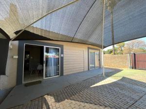 a house with a large roof with a patio at 1 on Titania in Polokwane