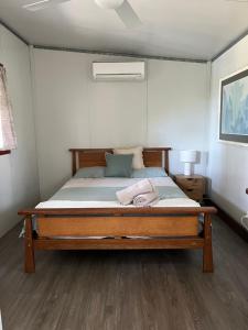 a bedroom with a large bed with a wooden frame at Three Rivers Cabin in Yandina