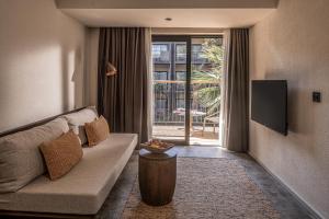 ein Wohnzimmer mit einem Sofa und einem TV in der Unterkunft Balmy Beach Resort Kemer in Kemer