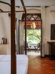 Lamrin Ucassaim Goa A 18th Century Portuguese Villa في Moira: غرفة نوم مع باب مفتوح إلى الفناء