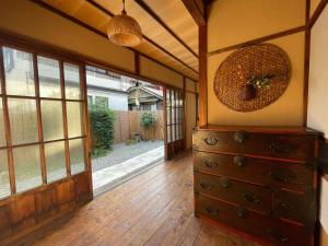 um quarto com uma cómoda e uma porta de vidro deslizante em 古民家の宿 鎌倉楽庵 em Kamakura