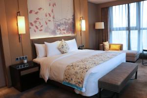 Uma cama ou camas num quarto em Wanda Realm Huangshi