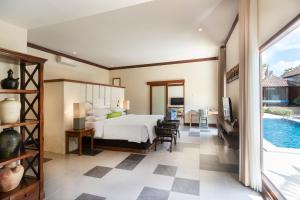 a bedroom with a bed and a pool at Rama Residence Petitenget in Seminyak