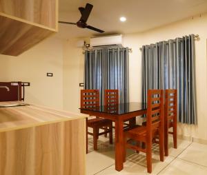 uma sala de jantar com uma mesa de madeira e cadeiras em Grand Residency & Resort em Varkala