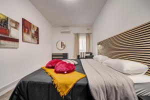una camera da letto con un grande letto con coperte e cuscini di St Julians apartment 1 a San Giuliano