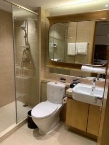 y baño con aseo, lavabo y ducha. en Slow Apartment, en Guangzhou