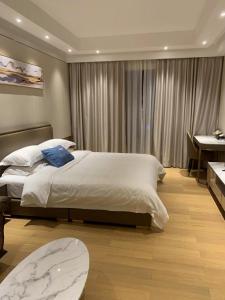 1 dormitorio con 1 cama grande y escritorio en Slow Apartment, en Guangzhou