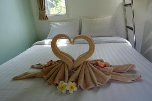 two swans made out of towels on a bed at Koh Mak Living in Ko Mak