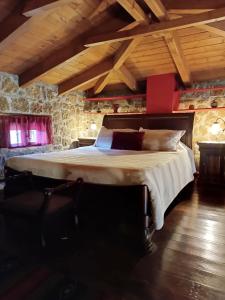 - une chambre avec un grand lit dans une pièce dotée de plafonds en bois dans l'établissement Ξενώνας Λίκνο, à Synikia Mesi Trikalon