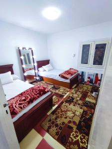 sypialnia z 2 łóżkami i dywanem w obiekcie LARA Maamoura beach Alexandria w Aleksandrii