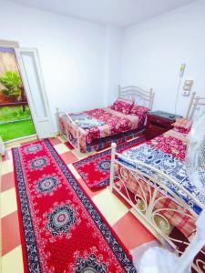 アレクサンドリアにあるLARA Maamoura beach Alexandriaのベッド2台が備わるカーペットフロアの客室です。