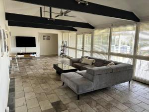 a living room with a couch and a flat screen tv at Relax, Resort Style in Rosebud