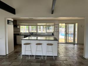 a kitchen with two bar stools and a counter at Relax, Resort Style in Rosebud