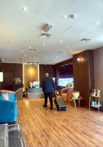 a man with a suitcase in a hotel lobby at AG Hotel in Abu Dhabi