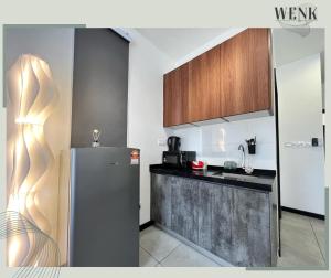 a kitchen with a refrigerator and a counter at Neu Suites 006 A in Kuala Lumpur