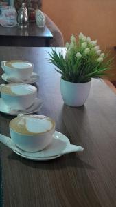 uma mesa com tigelas e um vaso com flores em Quanam Woods Hotel em Lodwar