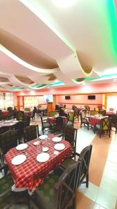 Quanam Woods Hotel في لودوار: غرفة طعام مع طاولة عليها لوحات