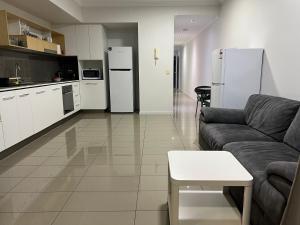 a living room with a couch and a kitchen with refrigerators at Fortitude Valley sharing apartments with other guests in Brisbane