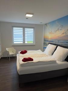 a bedroom with a bed with a painting of the ocean at Barrierefreie Ferienwohnungen in der Nähe der Golf- und Freizeitanlage in Mudau
