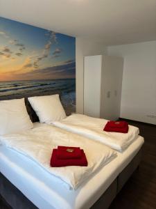 1 dormitorio con 2 camas y toallas rojas. en Barrierefreie Ferienwohnungen in der Nähe der Golf- und Freizeitanlage, en Mudau