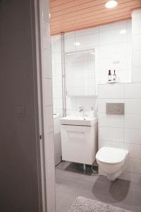 a white bathroom with a toilet and a sink at Condo Portsa - Viihtyisä asunto keskustassa in Turku