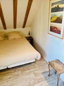 1 dormitorio con 1 cama y un banco en una habitación en La Vallee des Elements, en Chiddes