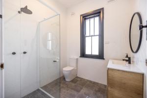 La salle de bains est pourvue de toilettes, d'un lavabo et d'une douche. dans l'établissement The Middle, à Adelong