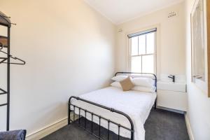 a small bedroom with a bed and a window at The Middle in Adelong