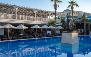 une grande piscine avec une statue devant un bâtiment dans l'établissement Golden Beach Resort & Spa, à Bodrum City